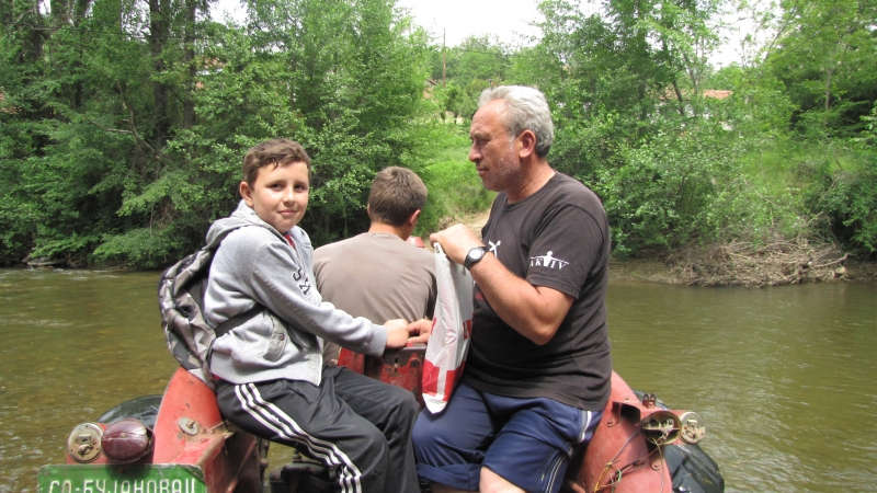 Marka i njegovog oca Gorana preko reke traktorom prevozi brat Miloš. Foto: S.Tasić/OK Radio